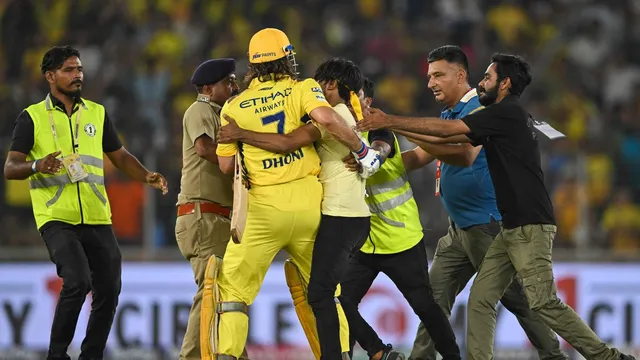 Security personnel tussle with a pitch invader who embraces Chennai Super Kings’ MS Dhoni during the Indian Premier League (IPL) Twenty20 cricket match between Gujarat Titans and Chennai Super Kings at the Narendra Modi Stadium in Ahmedabad on May 10, 2024