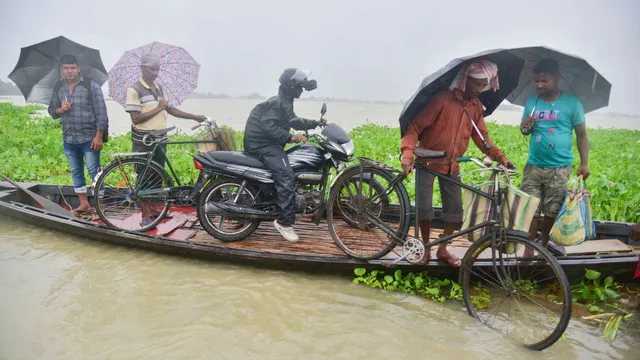 Villagers use a boat to travel acros a flood affected area after heavy rainfall, in Morigaon district, Tuesday, July 2, 2024