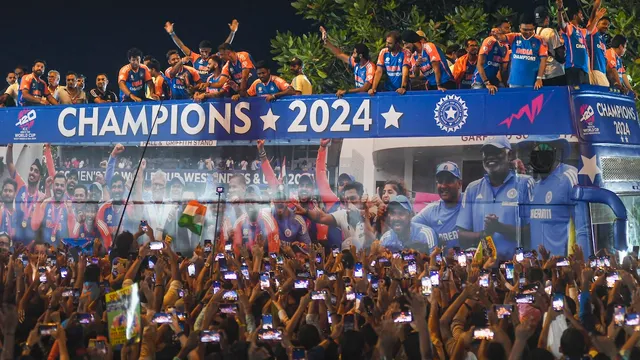 Players of the T20 World Cup-winning Indian cricket team with the championship trophy acknowledge fans during their open bus victory parade, in Mumbai, Thursday, July 4, 2024.