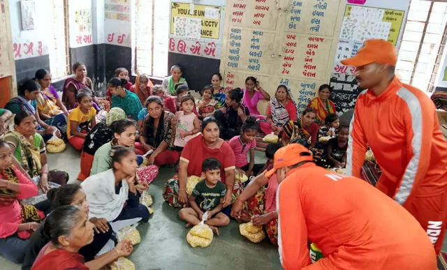 NDRF personnel with people living in coastal and low-lying areas of Gujarat after shifting them to a shelter home as part of precautionary measures ahead of the landfall of Cyclone Biparjoy