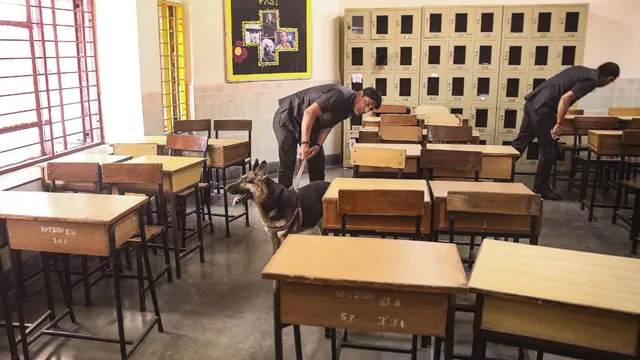 Security personnel inspect a class room at school after a bomb threat was received by the school via e-mail