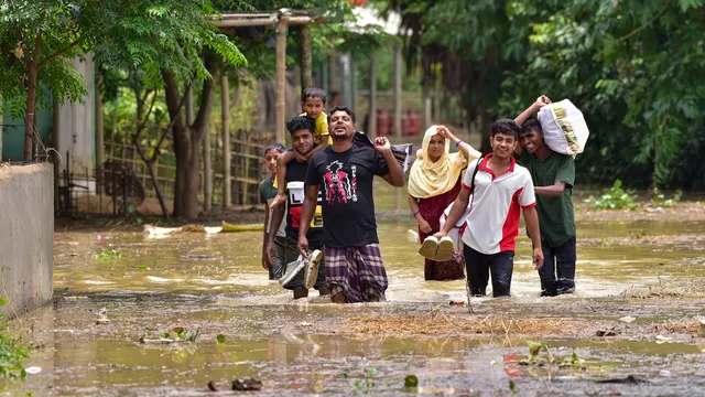 Villagers wade through a flooded area following rains in the aftermath of Cyclone Remal, in Hojai district, Assam, Friday, May 31, 2024