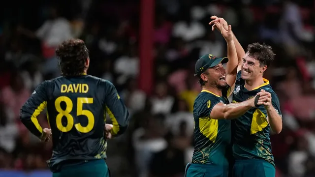 Australia's Pat Cummins is congratulated by teammates Marcus Stoinis and Tim David, during the men's T20 World Cup cricket match