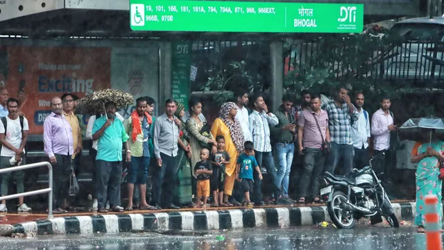 People take shelter amid monsoon rains, at Jangpura, in New Delhi, Thursday, July 25, 2024