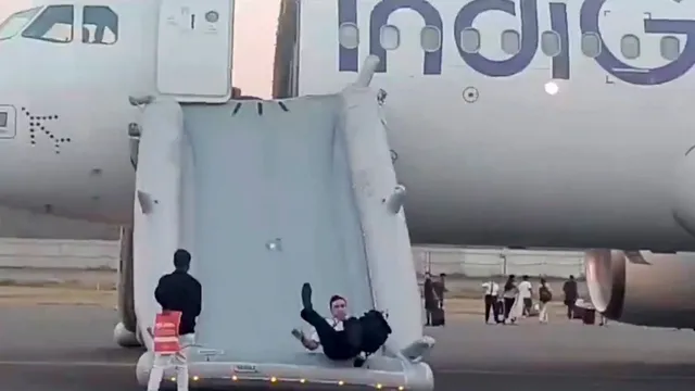 A pilot slides down from the Varanasi-bound IndiGo flight that received a bomb threat at the Indira Gandhi International Airport, in New Delhi, Tuesday, May 28, 2024