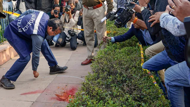 Police personnel investigate after two people jumped into the Lok Sabha chamber from the public gallery, and another two sprayed coloured gas from canisters while protesting outside the Parliament premises, in New Delhi, Wednesday, Dec. 13, 2023.