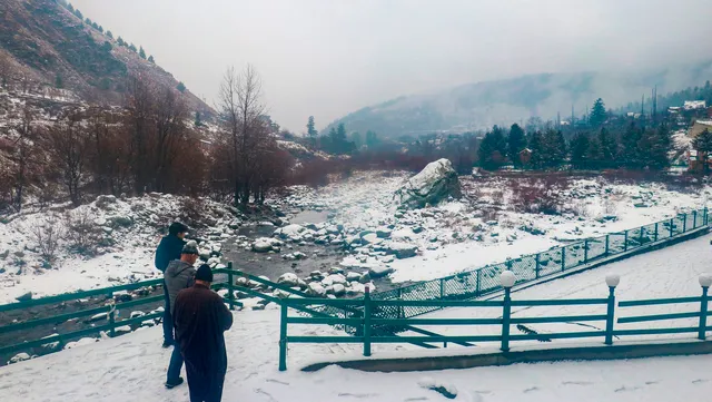 People stand at a snow covered field after light snowfall at Tangmarg in Baramulla district of north Kashmir, Monday, Jan. 29, 2024