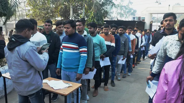 Candidates wait outside an examination centre to appear in the UP Police Constable recruitment exam, in Moradabad