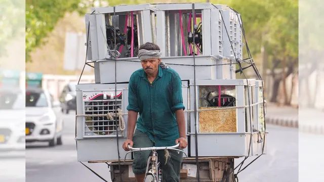 A vendor carries air coolers, seen on a hot summer day, in New Delhi, Tuesday, June 18, 2024.