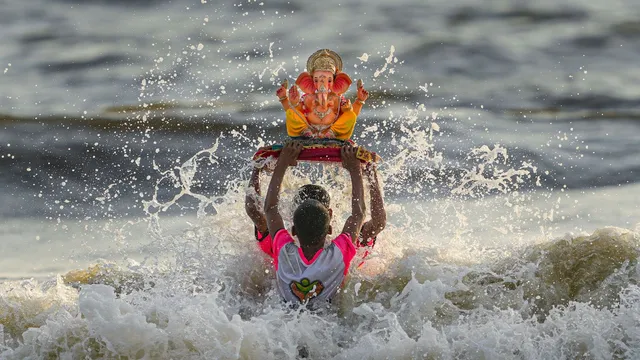 A devotee immerses an idol of Lord Ganesha in the Arabian Sea during the Ganesh Chaturthi festival, in Mumbai, Wednesday, Sept. 11, 2024.