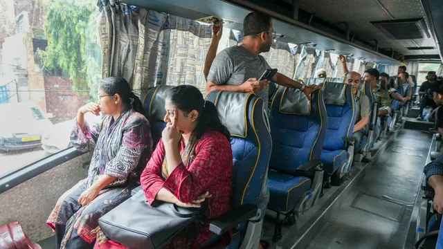 Bangladeshi tourists board a bus to reach the Petrapol border, in Kolkata, Tuesday, Aug. 6, 2024.