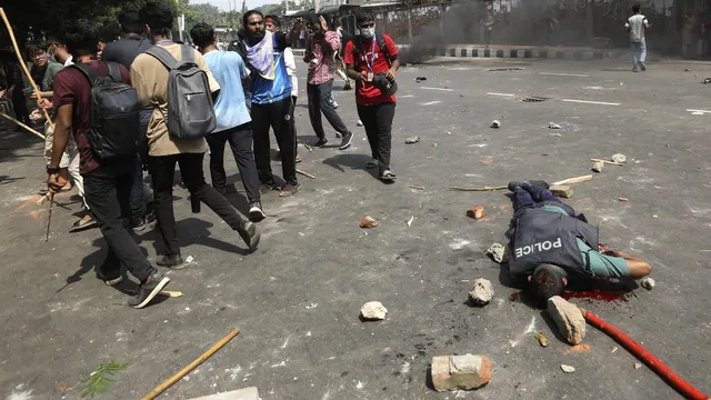 An injured policeman lies on a street during clashes with students during dayslong protests over the allocation of government jobs, in Dhaka, Bangladesh, July 18, 2024