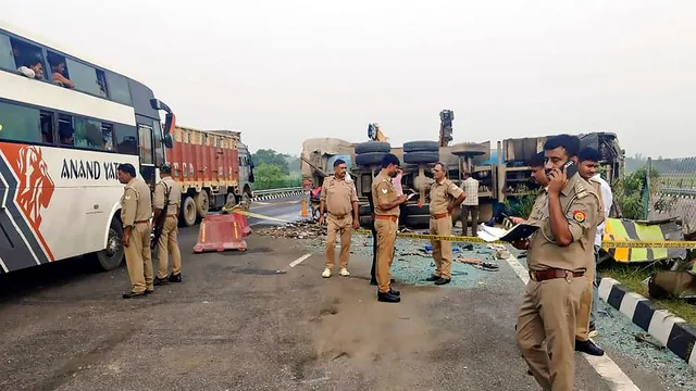 Police personnel stand near an overturned vehicle after an accident, in Unnao district, Wednesday, July 10, 2024.