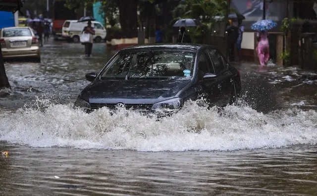  Vehicles ply on a flooded road following heavy monsoon rains