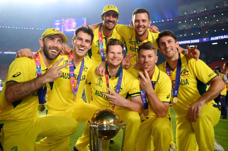 Two-time ODI World Cup winners - Glenn Maxwell, Pat Cummins, Mitchell Starc, Steven Smith, Josh Hazlewood, David Warner, and Mitchell Marsh - strike a pose with the trophy, India vs Australia, Men's ODI World Cup final, Ahmedabad, November 19, 2023 - sportzpoint.com