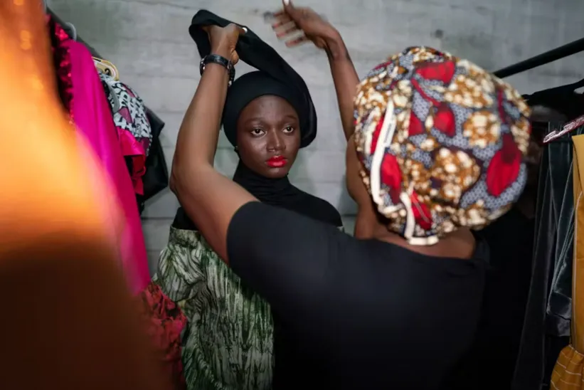 Ghanaian designer Zakiyya Ahama ties a model’s head wrap. Ernest Ankomah/Getty Images
