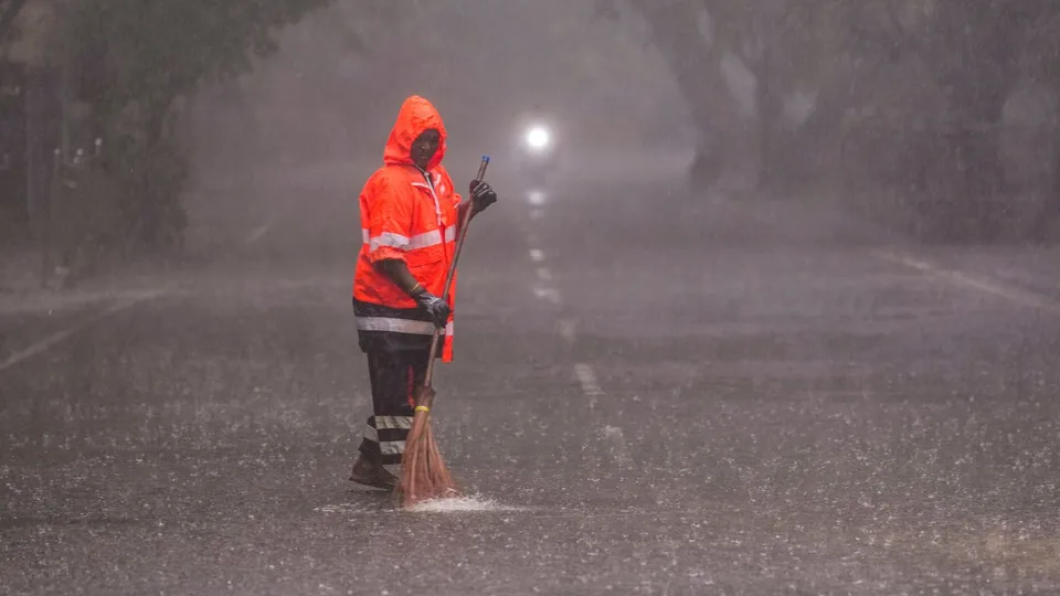 Widespread rains lash parts of Tamil Nadu as a sanitation worker cleans a street, in Chennai, Thursday, Dec. 12, 2024.