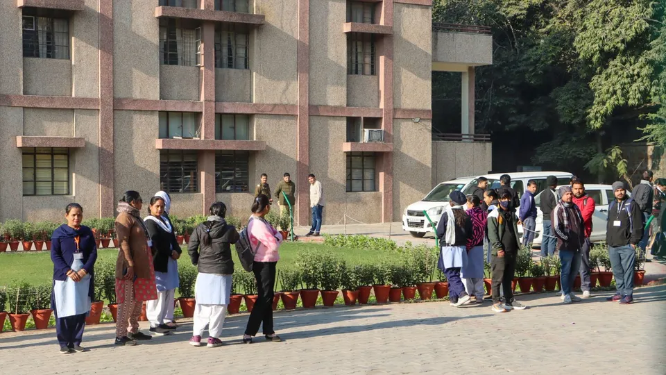 Officials with a sniffer dog inspect the premises of the Cambridge School at Shri Niwas Puri after it received bomb threat over email, in New Delhi, Friday, Dec. 13, 2024.