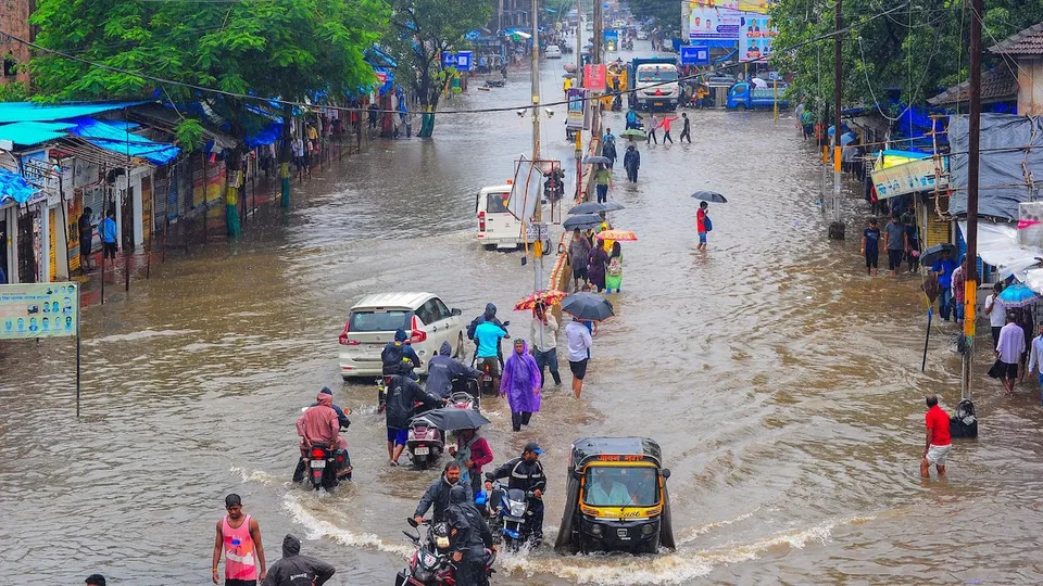 Commuters on a waterlogged road during monsoon rainfall, at Nalasopara in Palghar district, Thursday, July 20