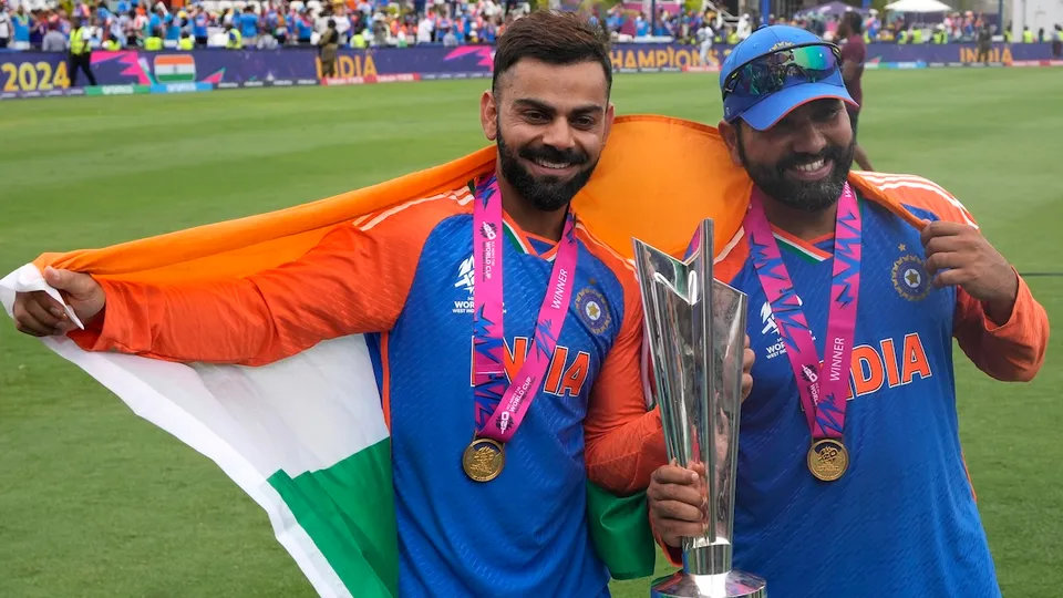 Virat Kohli, left, and captain Rohit Sharma pose with the winners trophy after defeating South Africa in the ICC Men's T20 World Cup final cricket match at Kensington Oval in Bridgetown, Barbados, Saturday, June 29, 2024.