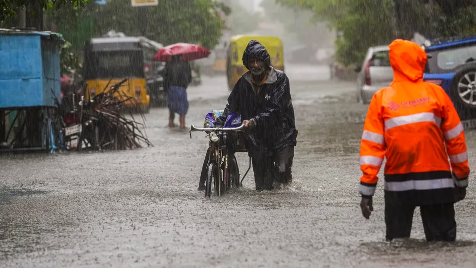 A commuter on a waterlogged road during heavy rain owing to Cyclone Michaung, in Chennai