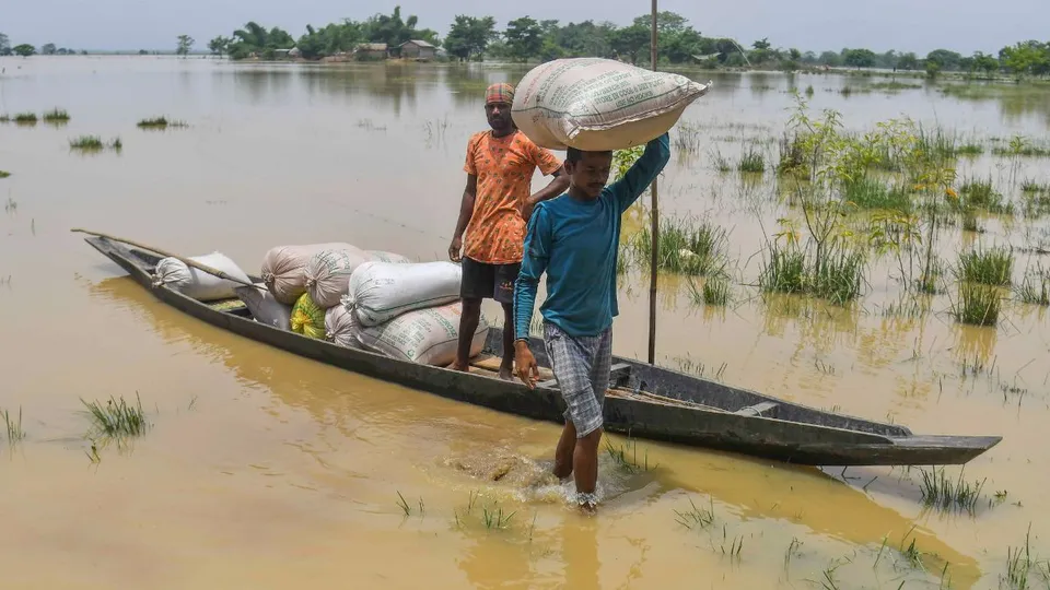 Villagers shift from a flood affected area to a safer place following heavy rainfall, in Nagaon district, Sunday, July 7, 2024